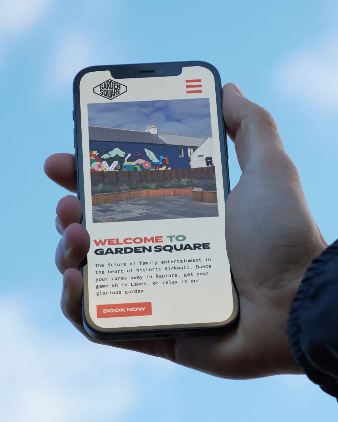 A hand holding the garden square hospitality website on an iphone