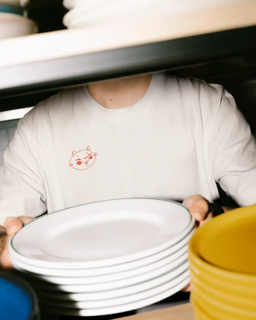 A mockup of a restaurant staff member wearing a miso cheesy t-shirt