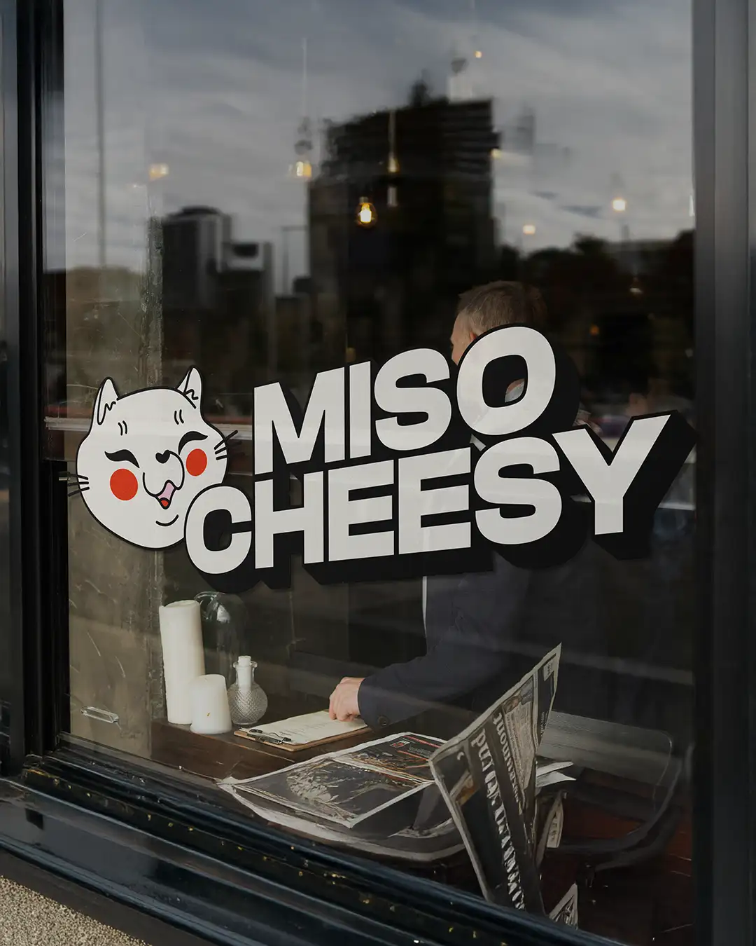 Miso Cheesy logo on a restaurant window