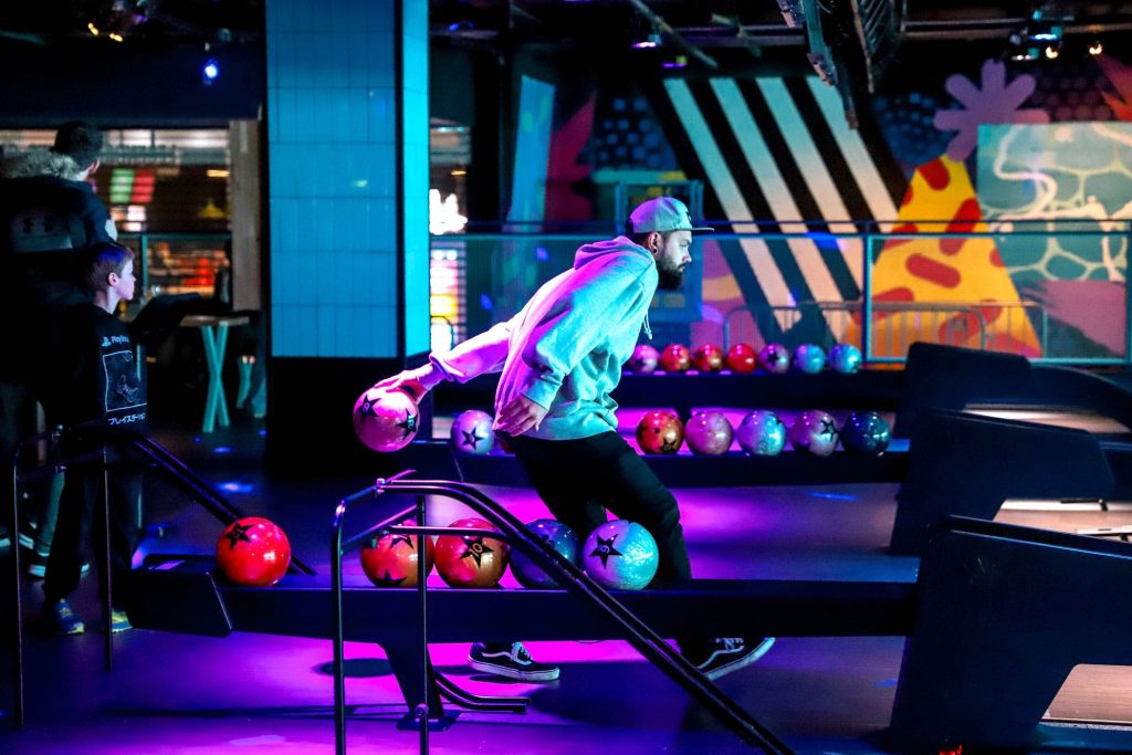 a man bowling at Start pins