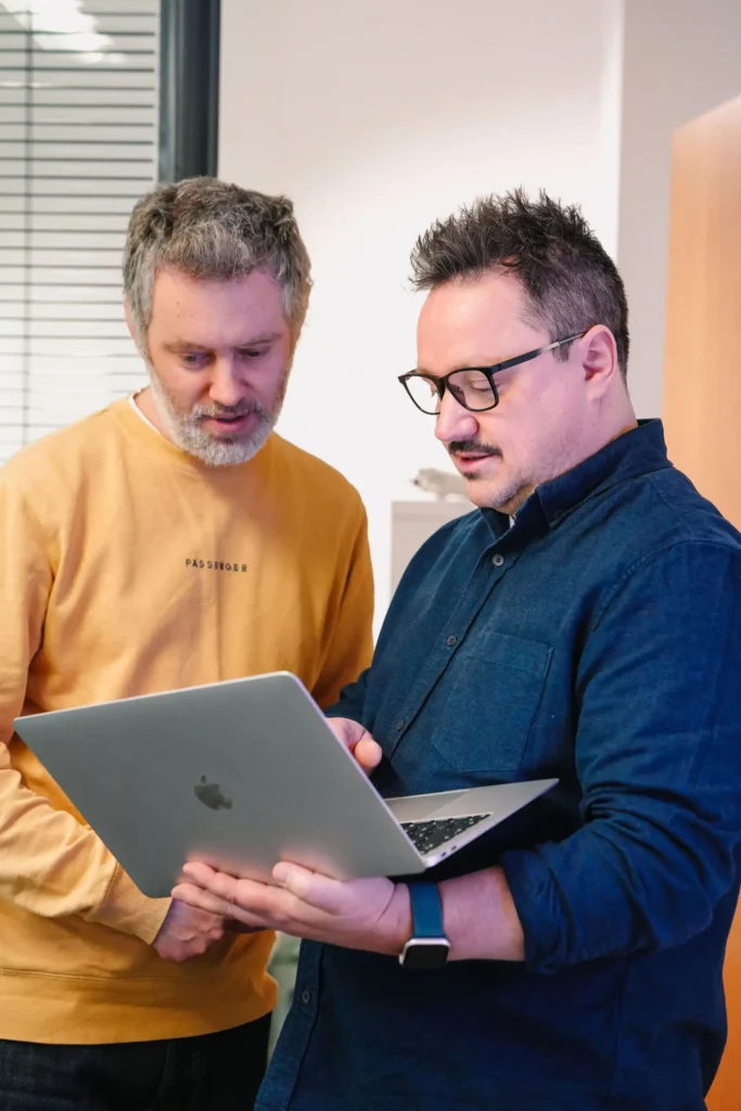 Danny and Peter at Little Green Jesus, discussing a web project, including SEO reports on a laptop
